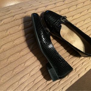 Clarks woman’s black loafers with gold hardware. Black embosssed leather